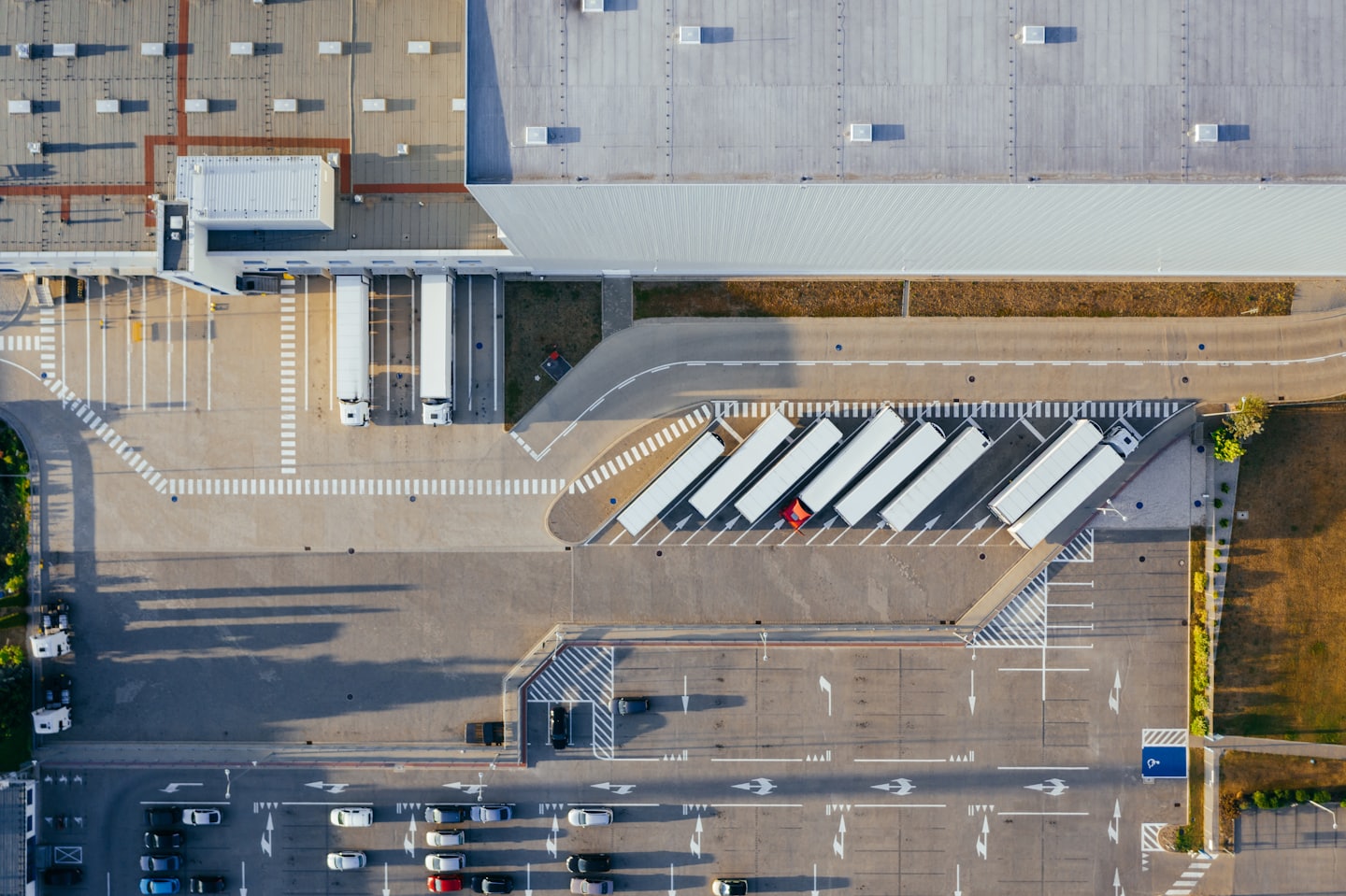Semi-trailer trucks at a busy logistics warehouse loading dock.